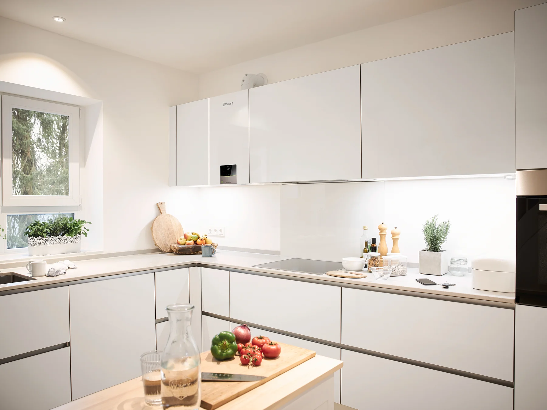 Caldera Vaillant ecoTEC exclusive integrada entre los armarios blancos de una cocina contemporánea