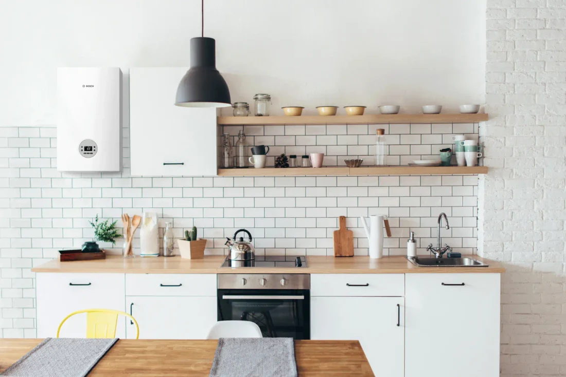 Caldera Bosch Condens 1200 W integrada en una cocina blanca con encimera de madera — reparacioncalderas.madrid